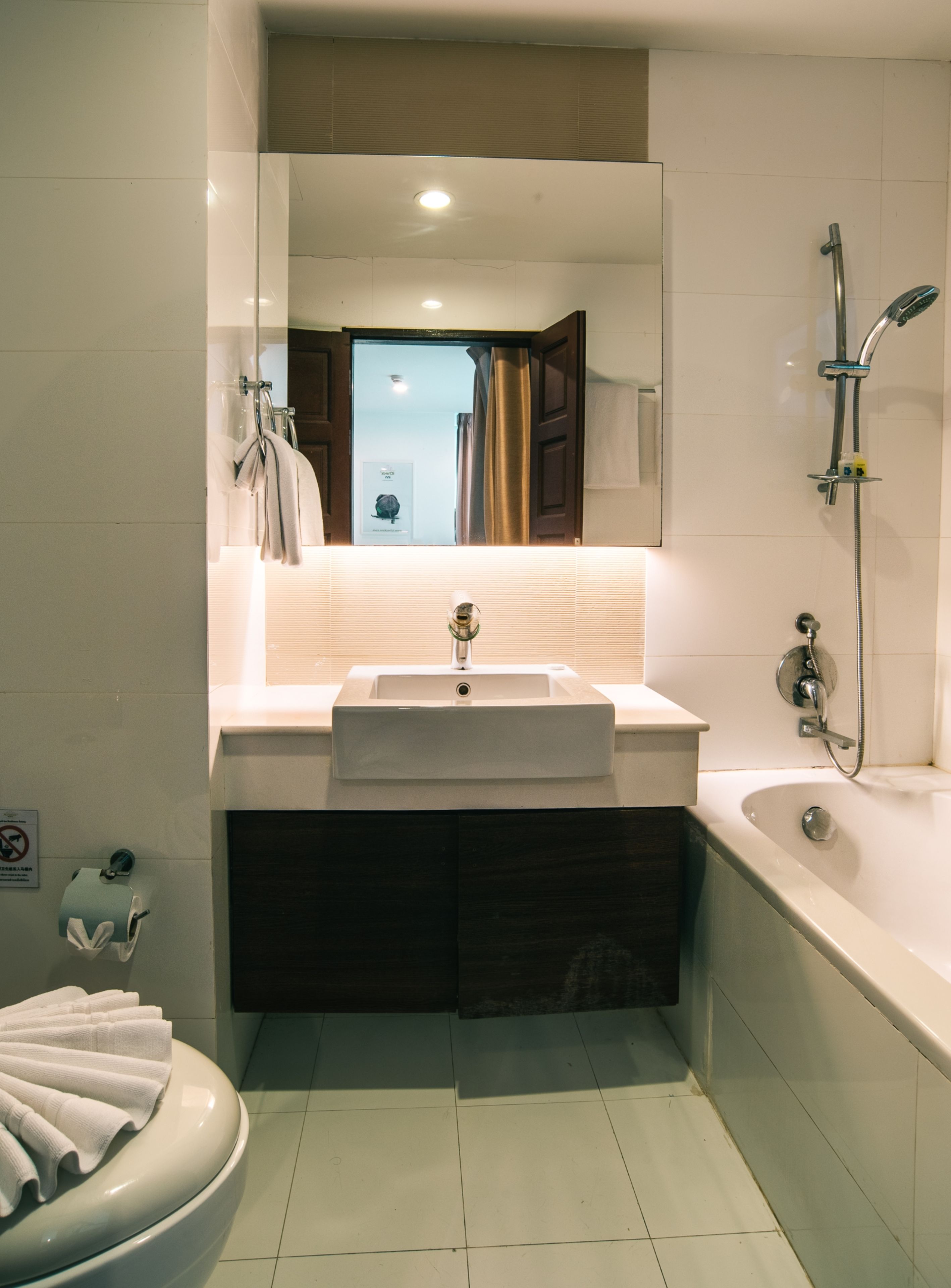 Een moderne badkamer met een wastafel, toilet en bad.