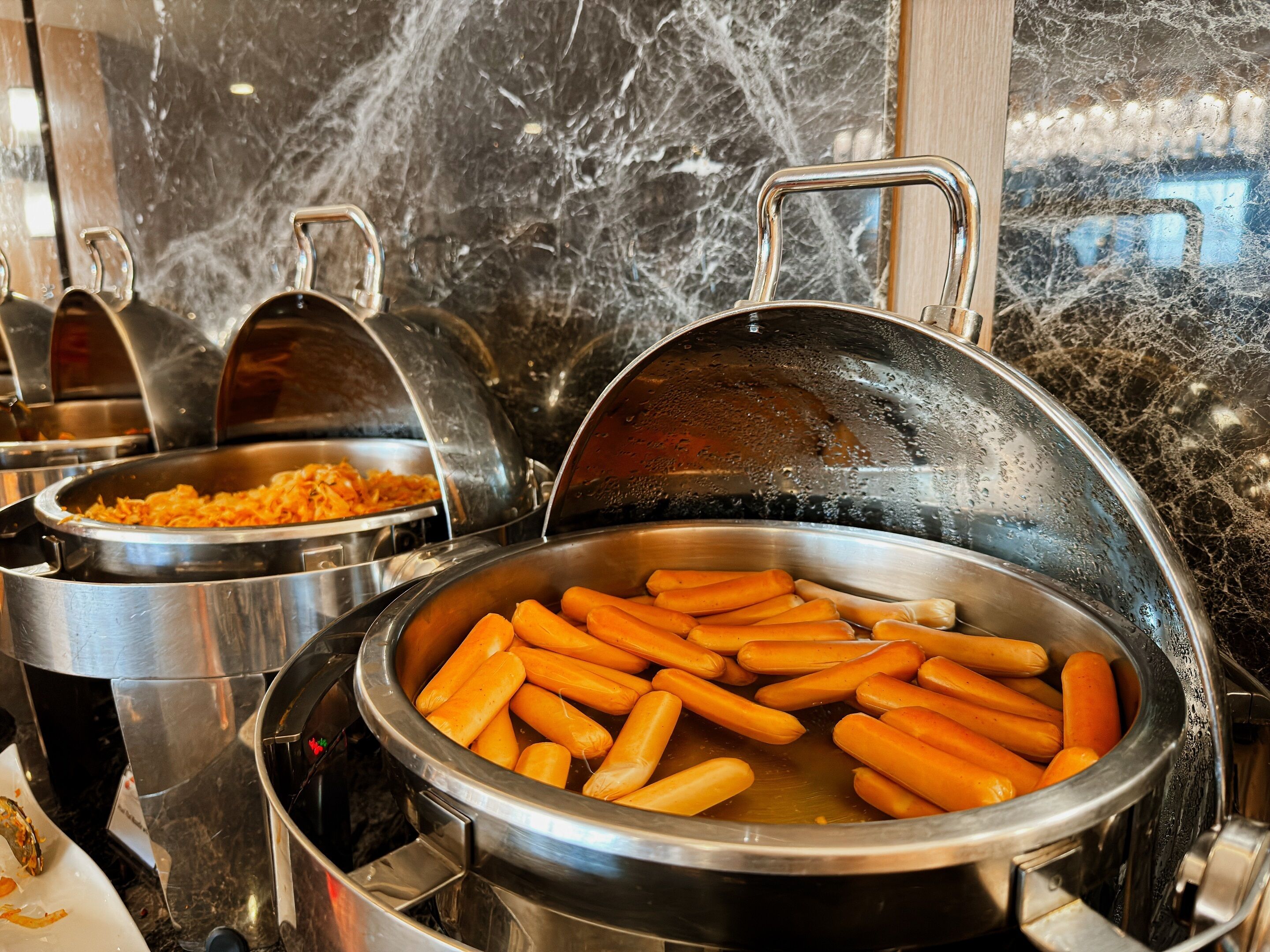 Un buffet proposant divers plats, dont un grand plat de carottes.