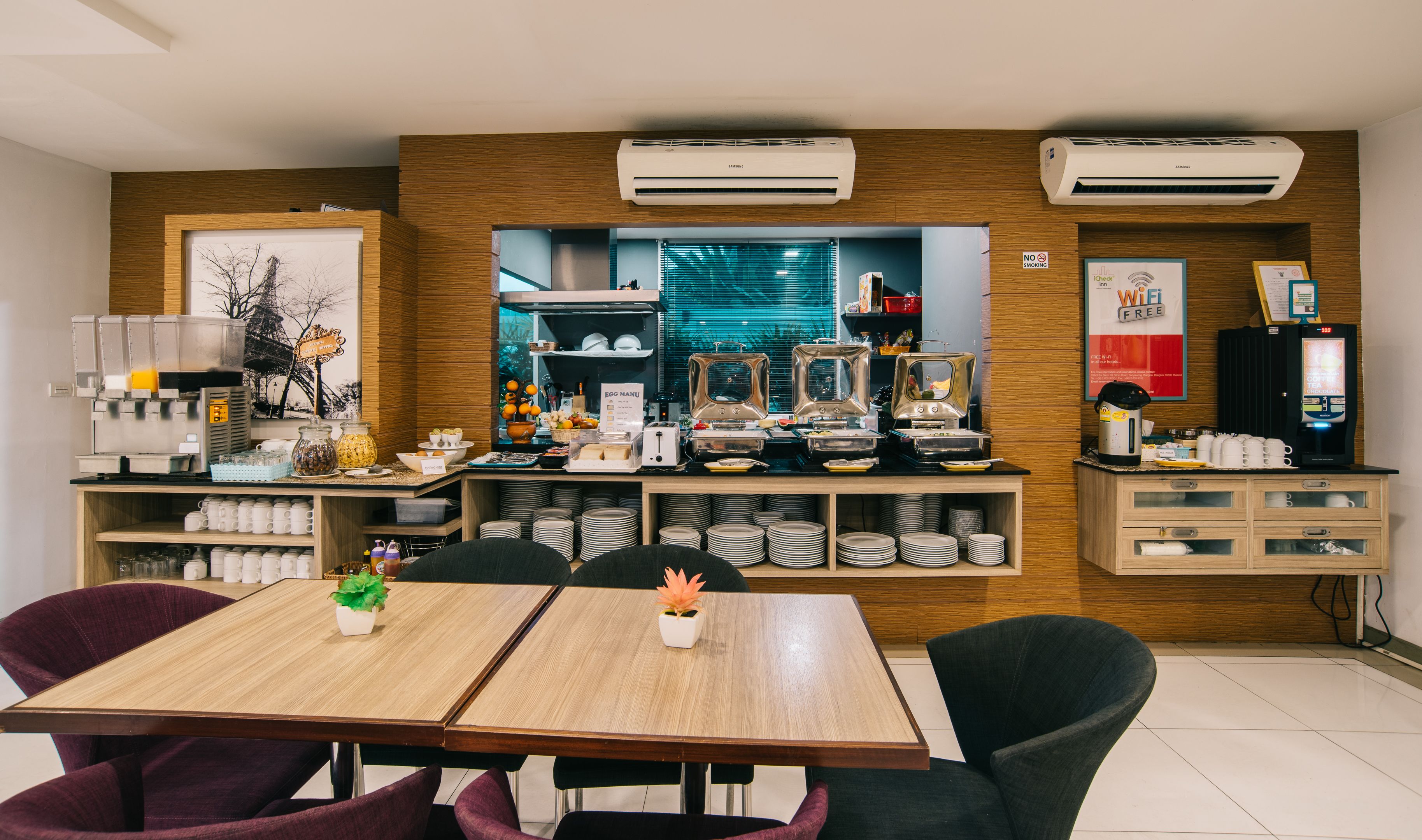 Un comedor moderno con una mesa de madera, sillas y una cafetera.