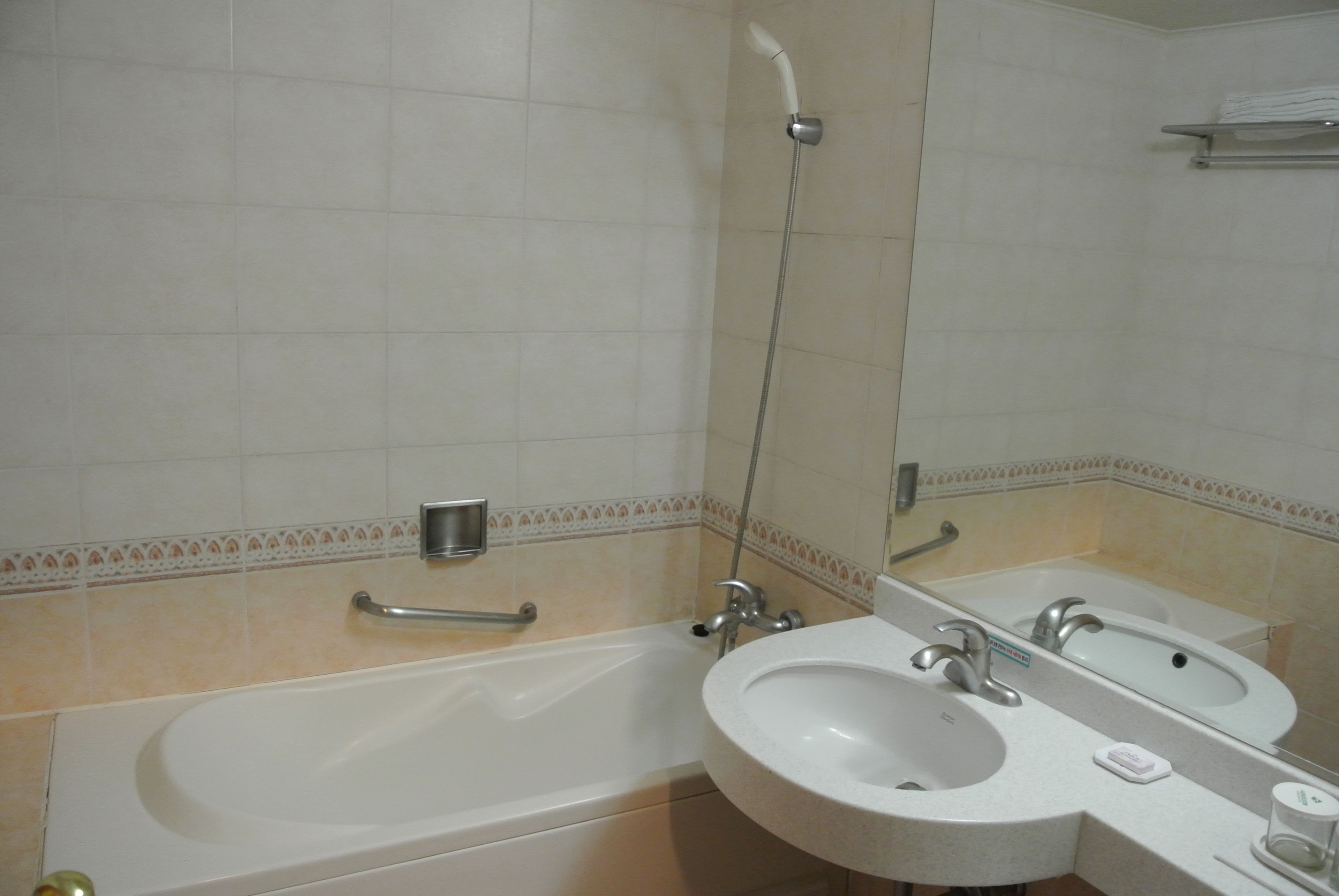Un baño con bañera, dos lavamanos, ducha y espejo.