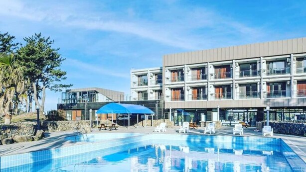 Una piscina con un edificio moderno al fondo.