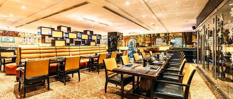 A restaurant with booths and tables, a patterned carpet, and a Christmas tree.