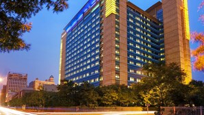 A multi-story hotel with a prominent blue-lit facade and a classic architectural design. - Teda, Tianjin-marriott Executive Apartments (Tianjin)