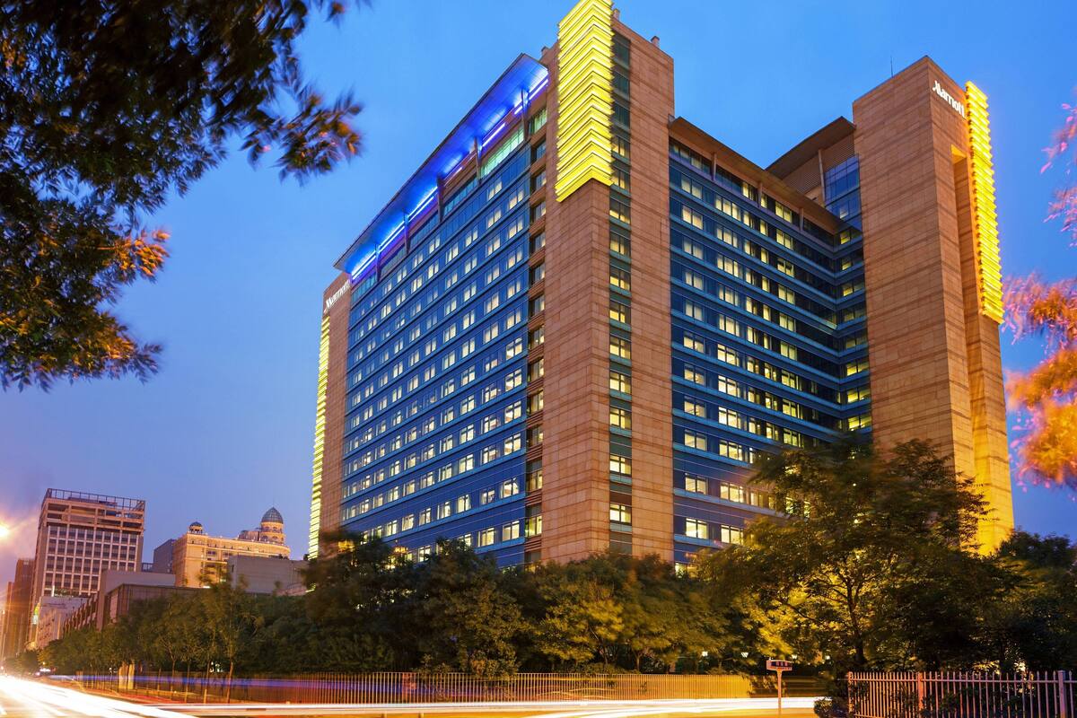 A multi-story hotel with a prominent blue-lit facade and a classic architectural design.