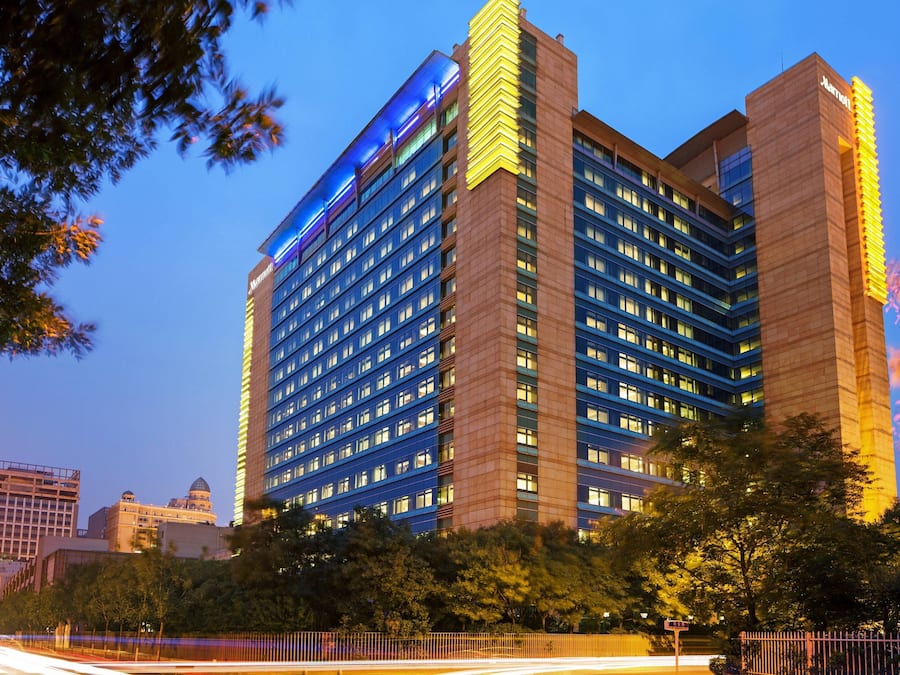 A multi-story hotel with a prominent blue-lit facade and a classic architectural design.