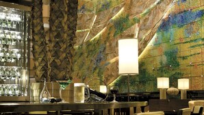 A bar area with a patterned wall, bar stools, and a glass display case. - Teda, Tianjin-marriott Executive Apartments (Tianjin)