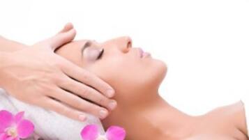 A person receiving a massage with a towel and pink flowers.