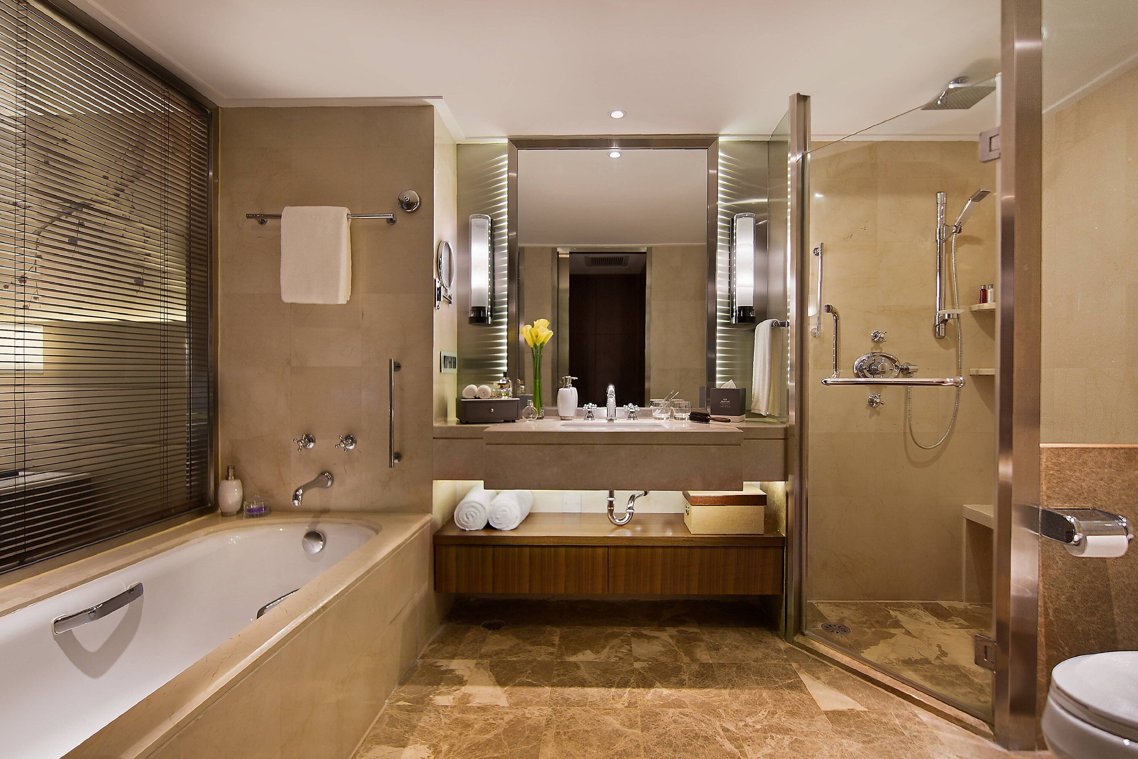 A modern bathroom with a bathtub, a shower, a vanity with a mirror, and a toilet.