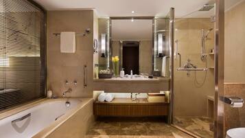 A modern bathroom with a bathtub, a shower, a vanity with a mirror, and a toilet.