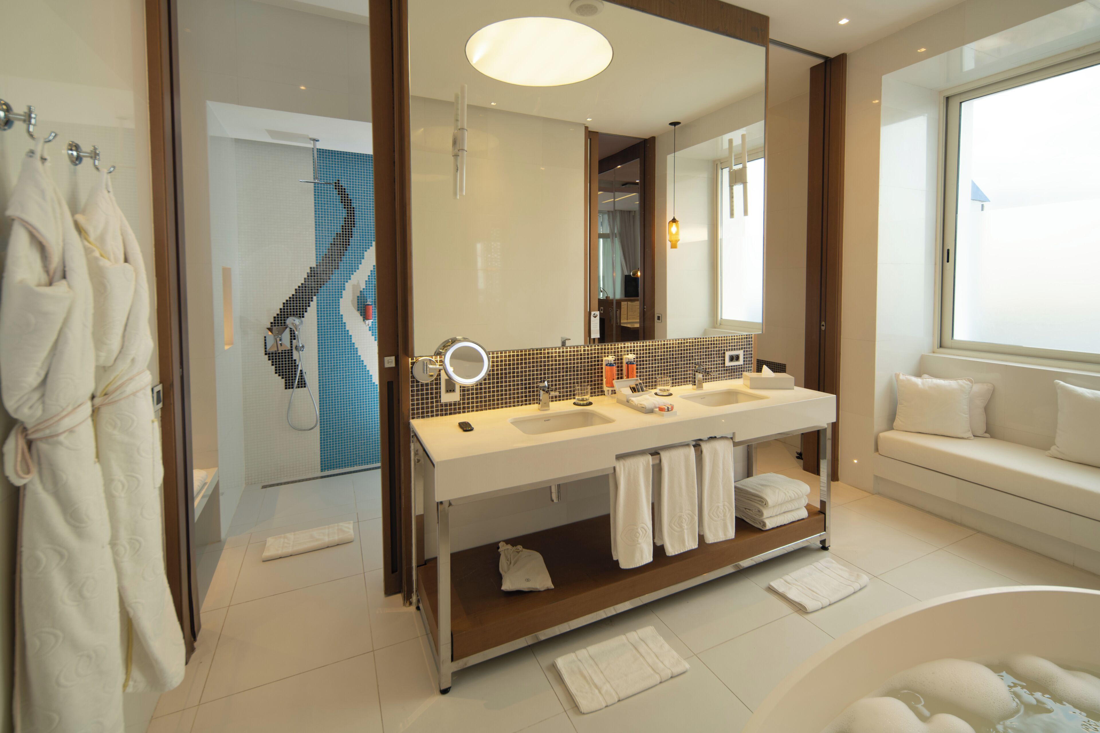 Un baño moderno con tocador doble, un espejo grande y una bañera.