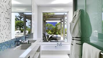 A modern bathroom with a large window, a bathtub, and a shower area.