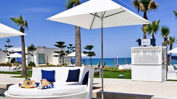Relax by the ocean in this serene lounge area, featuring a comfortable chair and umbrella.