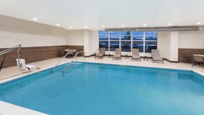 An indoor swimming pool with a view of the parking lot and buildings outside. - Holiday Inn Express & Suites Sandusky by IHG (Sandusky)
