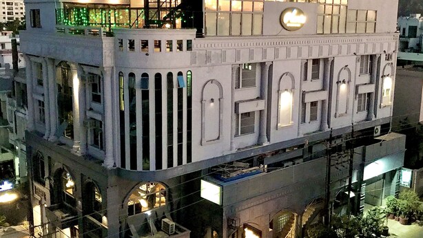 Um edifício com vários andares e design arquitetônico moderno, com varandas e janelas amplas.