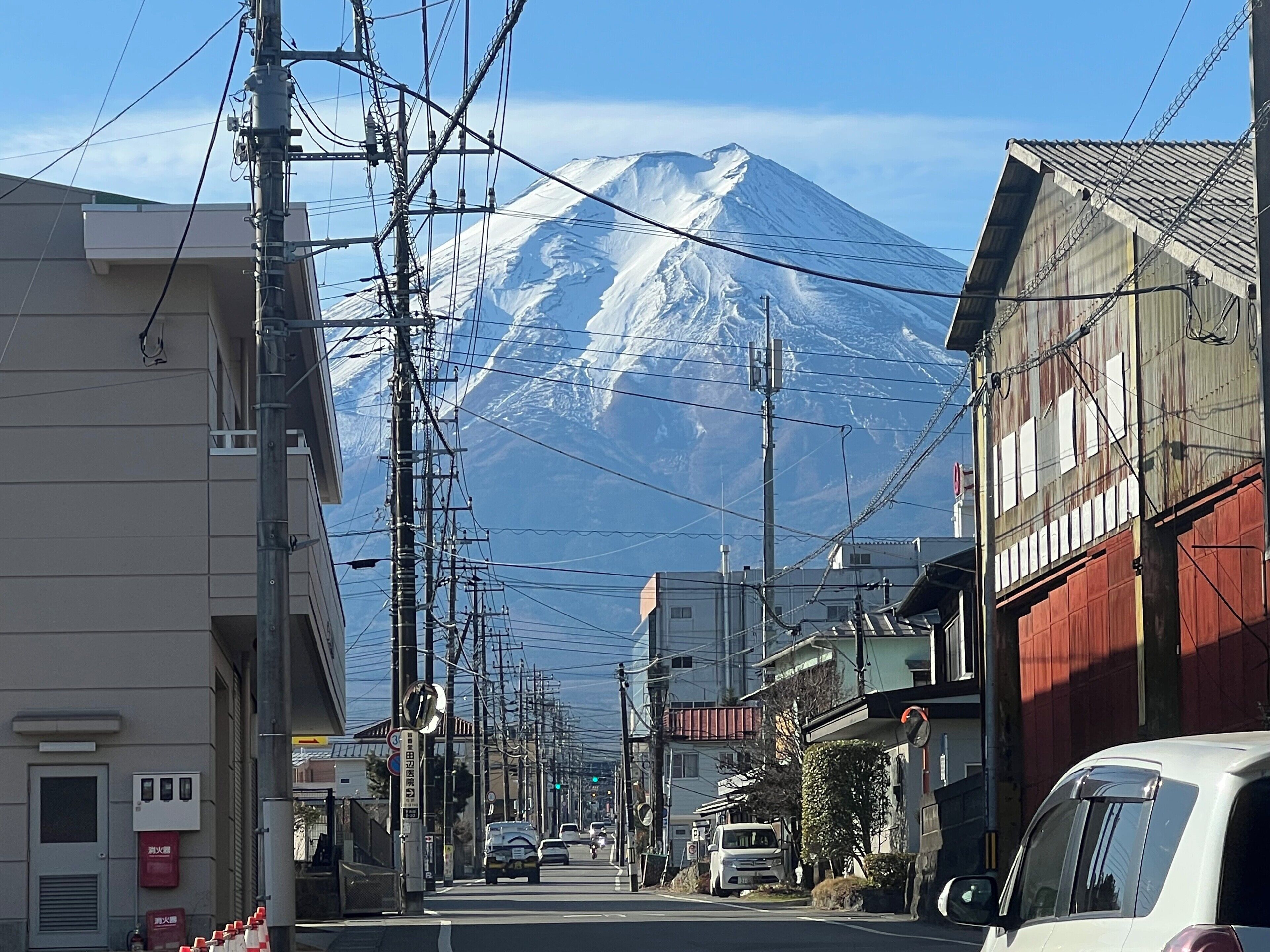 A street with buildings and a mountain in the background.