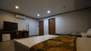 A hotel room with a bed, a television, a desk, and a wardrobe. - R.I Spa Hotel (Chungju)