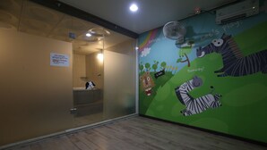 A children's play area with a mural of animals and a sign indicating a playroom. - R.I Spa Hotel (Chungju)