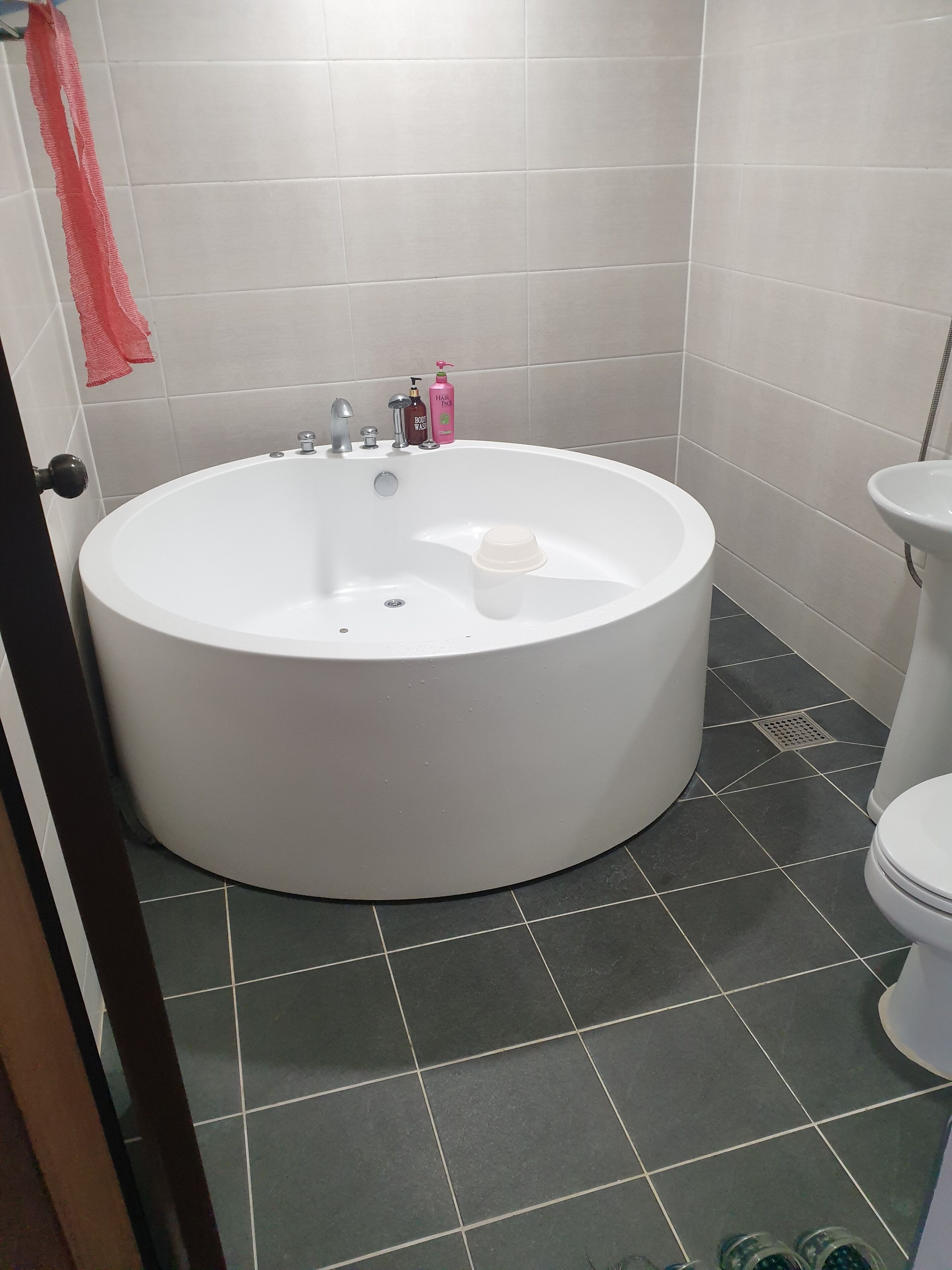 Un baño con una bañera grande, un inodoro y un lavamanos.
