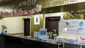 Un mostrador de recepción con un cartel que dice 'Information' y un arreglo floral decorativo encima.