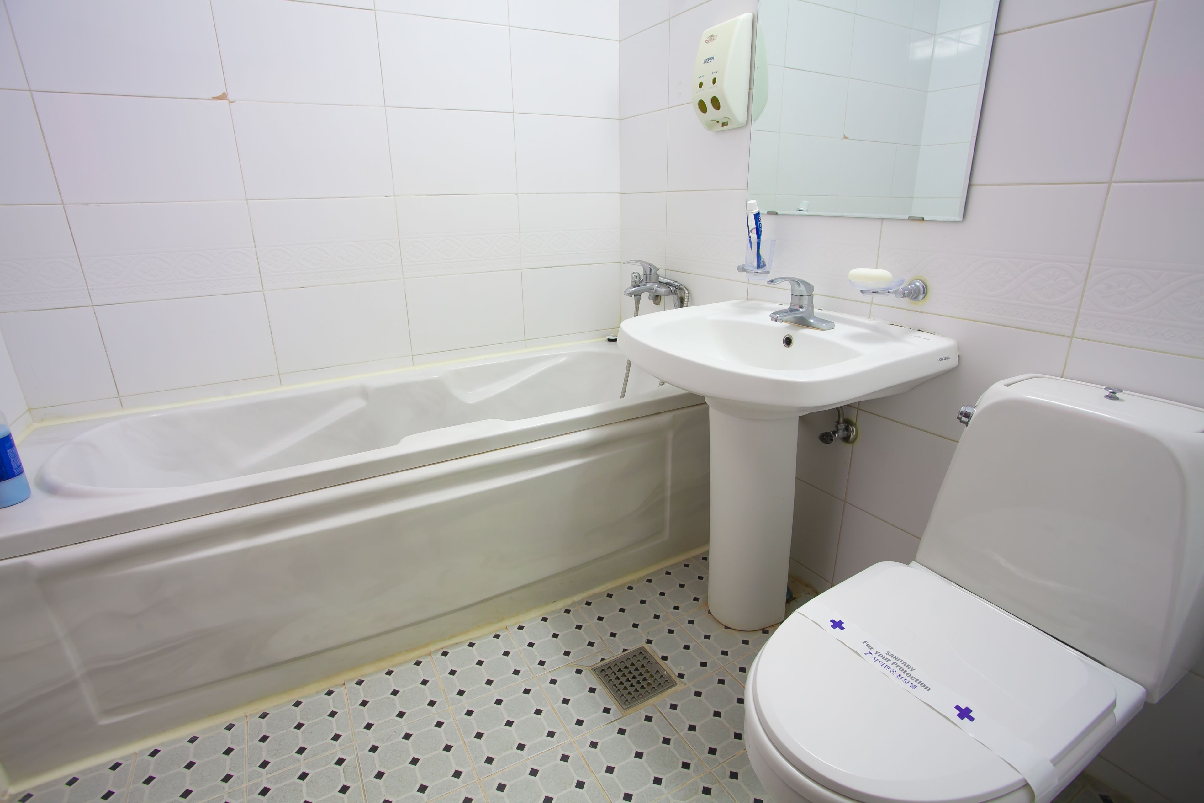 Un baño con bañera, lavabo e inodoro.