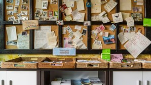 Un tablón de anuncios con varias notas, fotografías y guías de viaje.