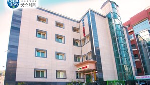 Un hotel moderno con varios pisos, ventanas amplias y una entrada destacada.
