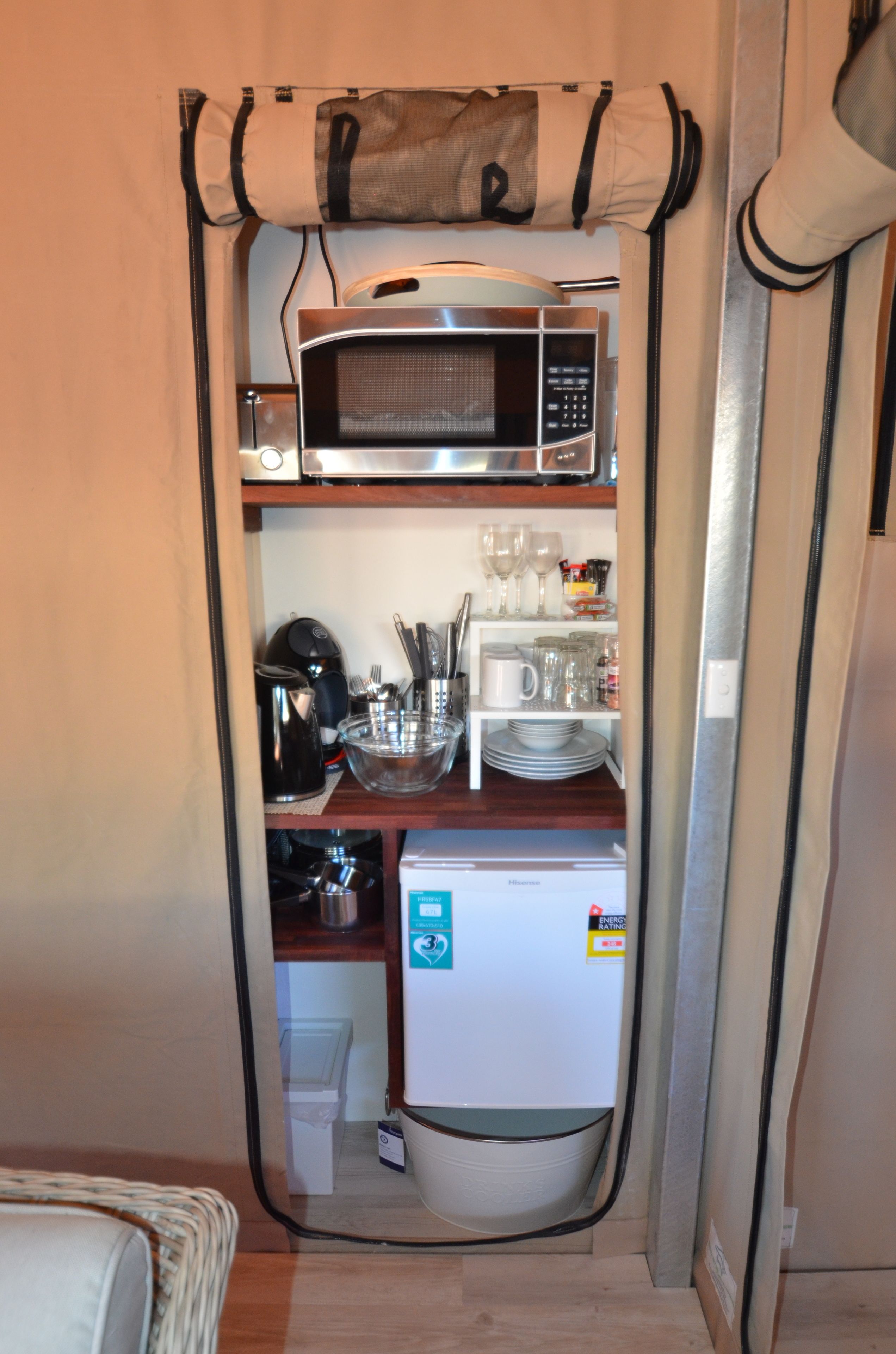 A compact kitchenette with a microwave, coffee maker, and a small refrigerator.