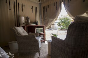 A cozy living area with wicker furniture, a television, and a small shelf with kitchen items.