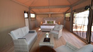 Una habitación con carpa, una cama, dos sofás y una mesa de centro.