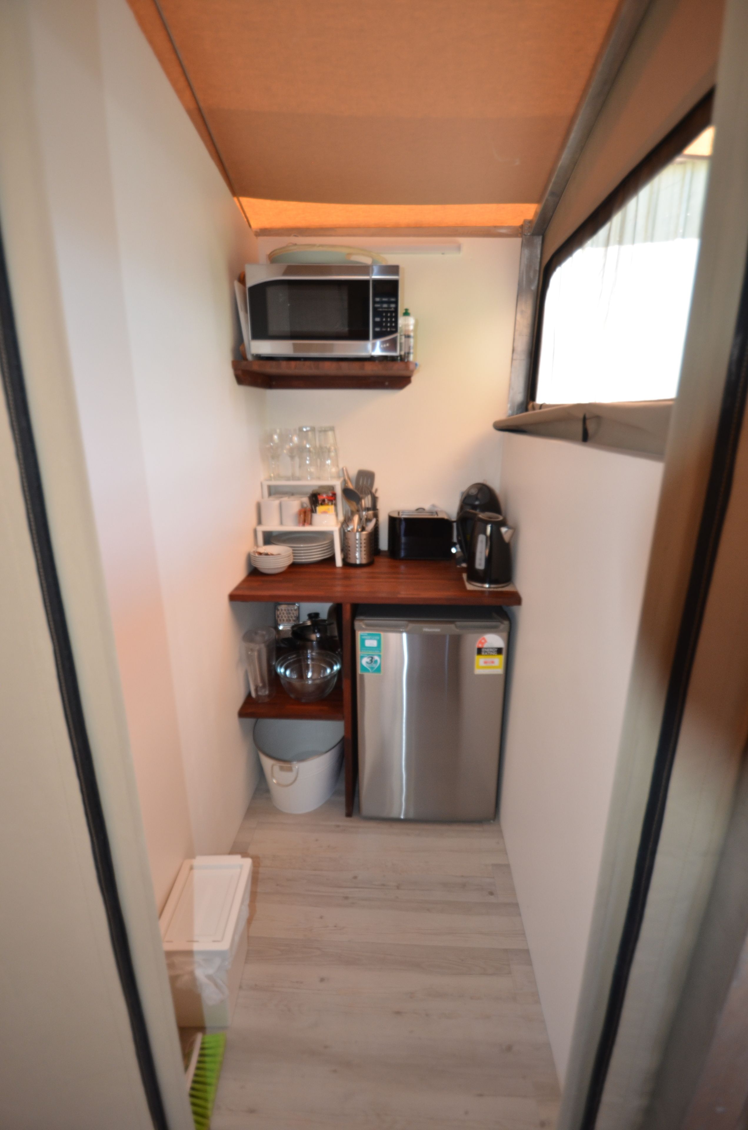 A compact kitchenette with a microwave, coffee maker, and small refrigerator.