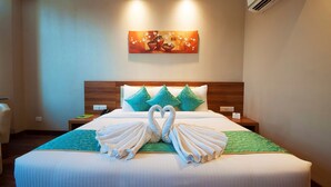 A hotel room with a neatly made bed, a painting on the wall, and a nightstand with a phone and a sign. - Hotel Le Roi Haridwar @ Har Ki Pauri Road (Haridwar)