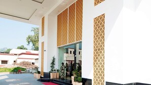 A modern building entrance with a red carpet, patterned wooden panels, and a clear view of the surrounding area. - Hotel Le Roi Haridwar @ Har Ki Pauri Road (Haridwar)