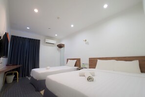 A hotel room with two beds, a desk, a TV, and an air conditioning unit. - T Hotel Kuala Perlis (Kuala Perlis)