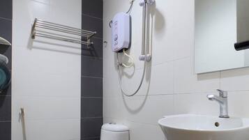 A bathroom with a toilet, a sink, and a shower.