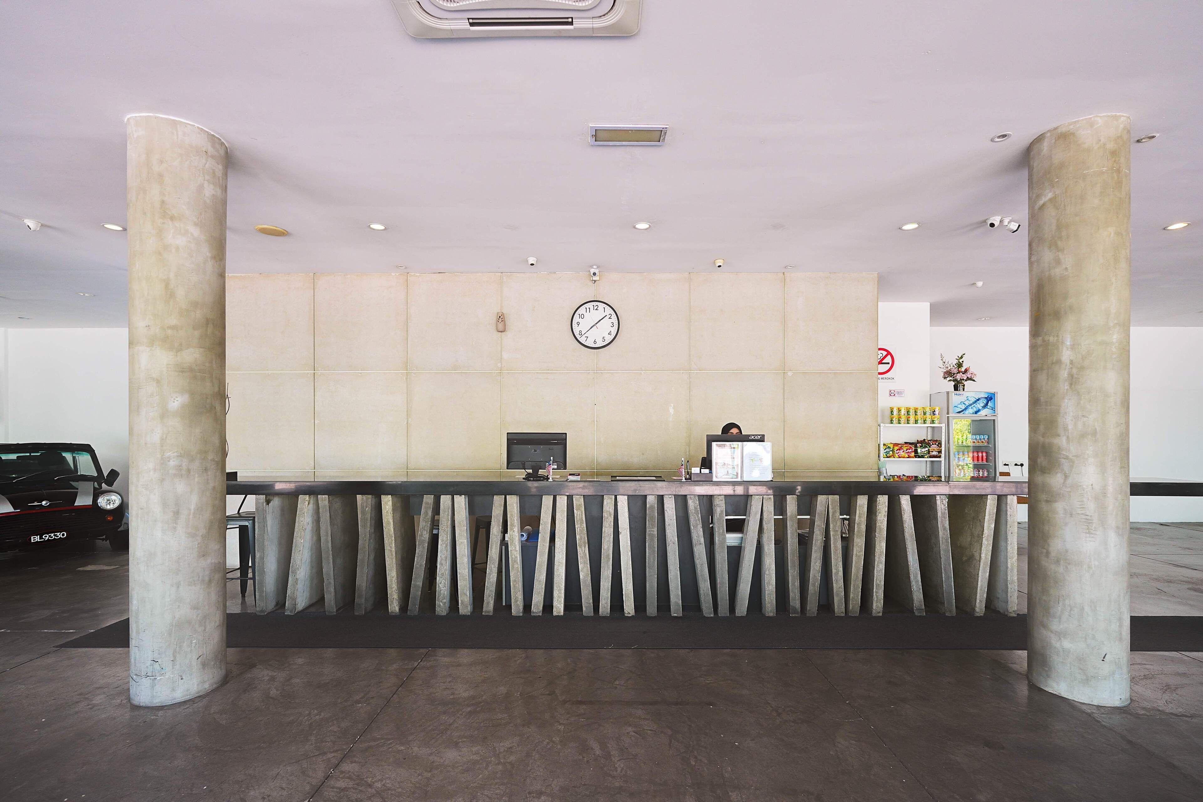 A reception area with a reception desk, a clock, and a wall-mounted security camera.