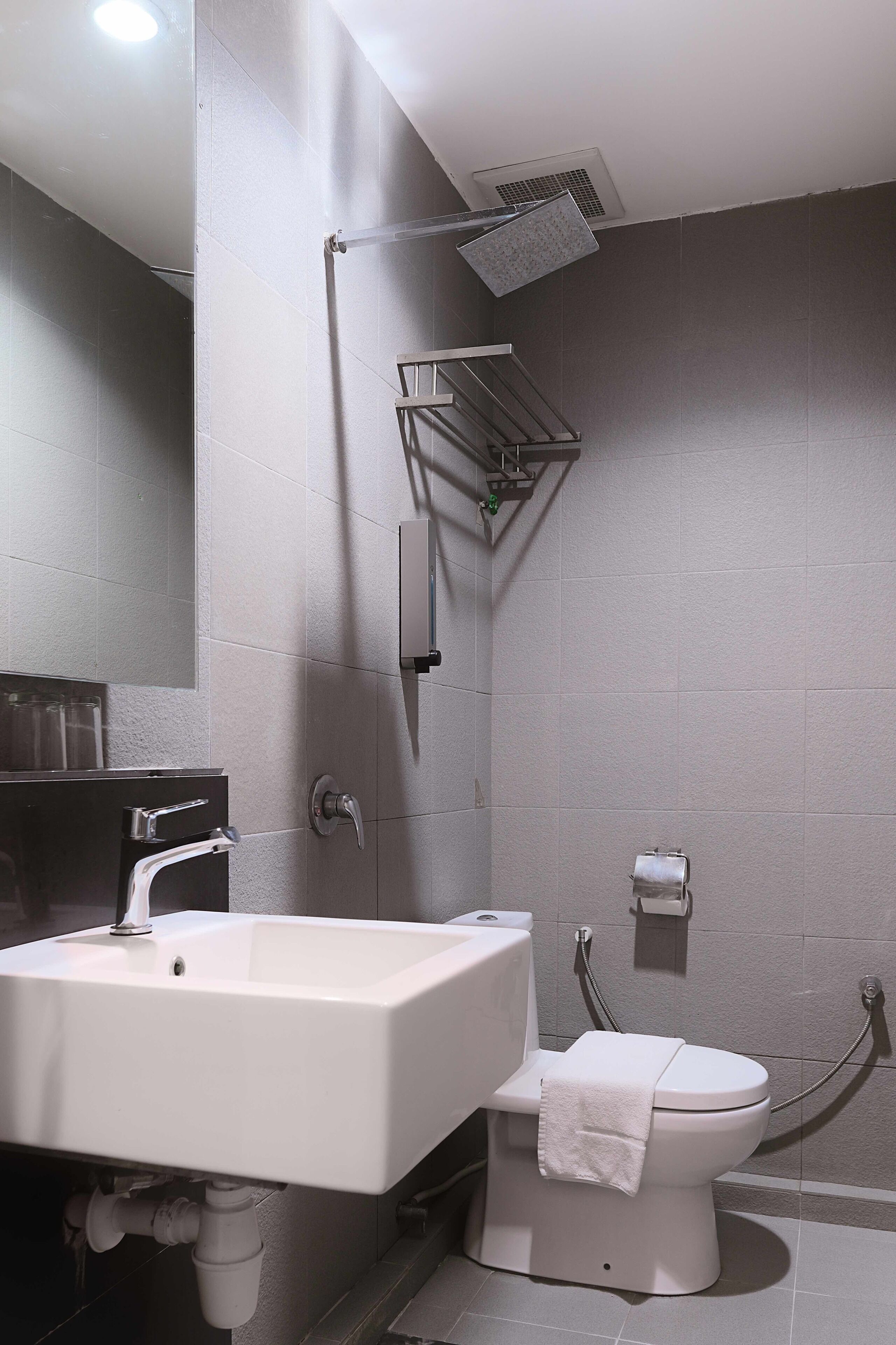 A modern bathroom with a white sink, toilet, and shower.