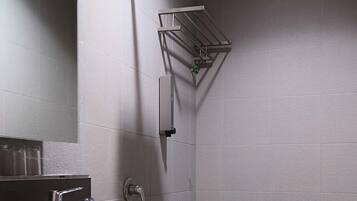 A modern bathroom with a white sink, toilet, and shower.