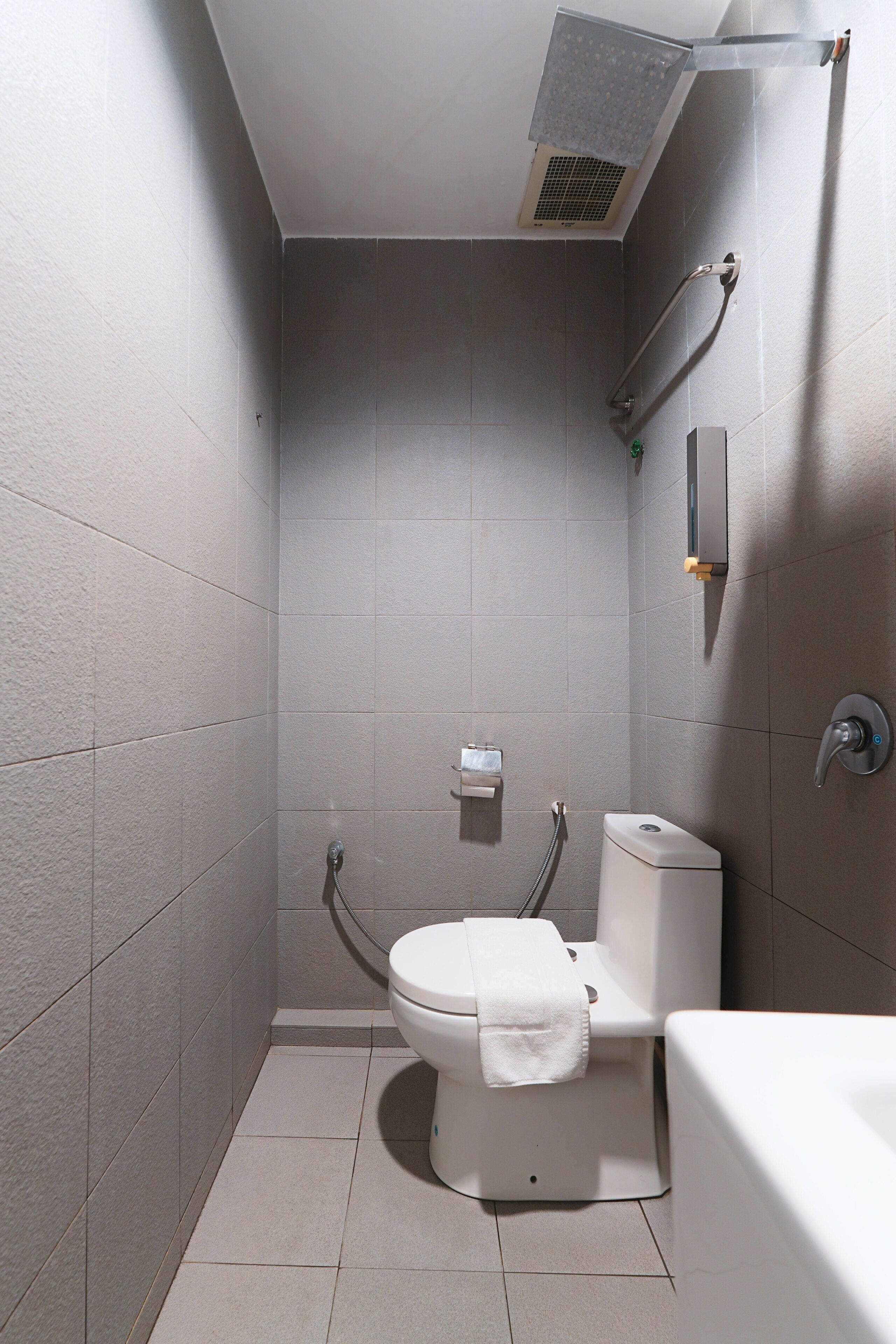 A small, modern bathroom with a shower, toilet, and sink.