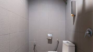 A small, modern bathroom with a shower, toilet, and sink.