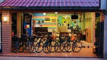 A colorful boutique with a tiled roof, bicycles parked outside, and a visible signboard.