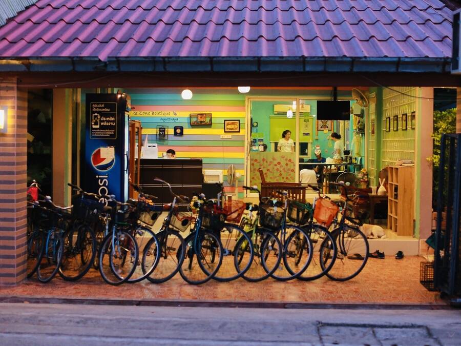 A colorful boutique with a tiled roof, bicycles parked outside, and a visible signboard.