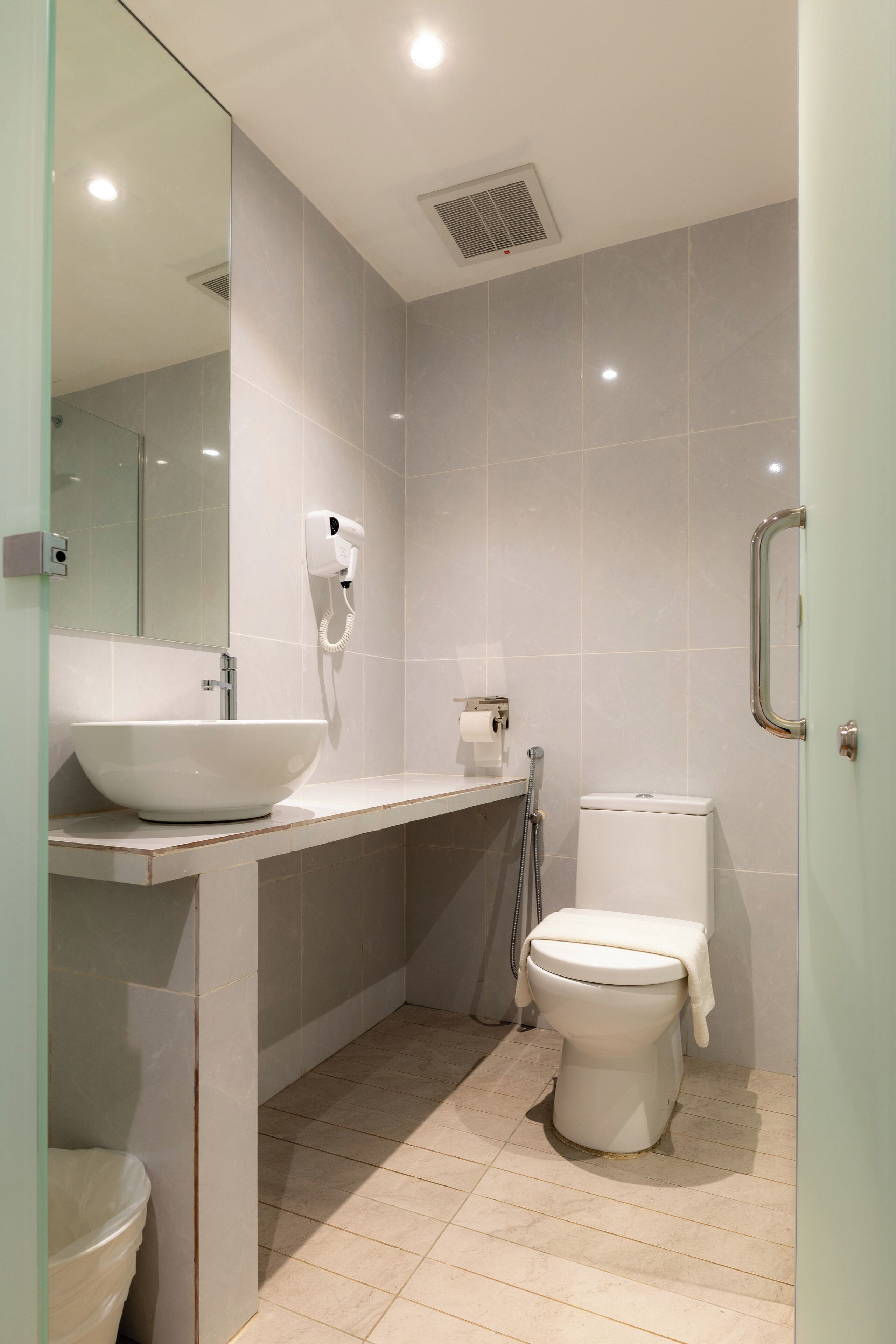 Un bagno moderno con lavandino, wc e doccia bianchi.