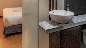 A modern bathroom with a large mirror, a white vessel sink, and a wooden vanity. - T+ Hotel Sungai Petani (Sungai Petani)