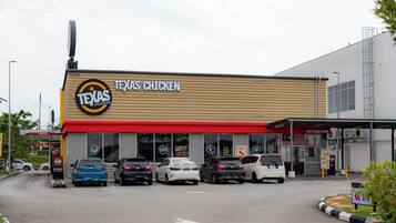 A Texas Chicken restaurant with a red awning and multiple cars parked in front.