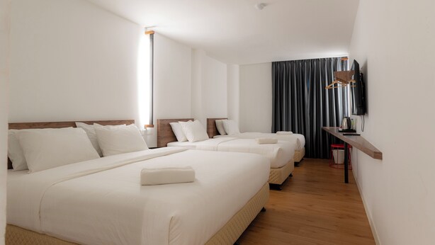 A hotel room with three beds, a TV, a desk, and a large window with curtains. - T+ Hotel Sungai Petani (Sungai Petani)