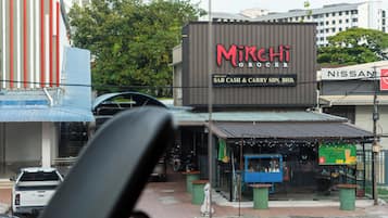Une épicerie nommée Mirchi, reconnaissable à son enseigne, à un chariot bleu et à une voiture garée devant.