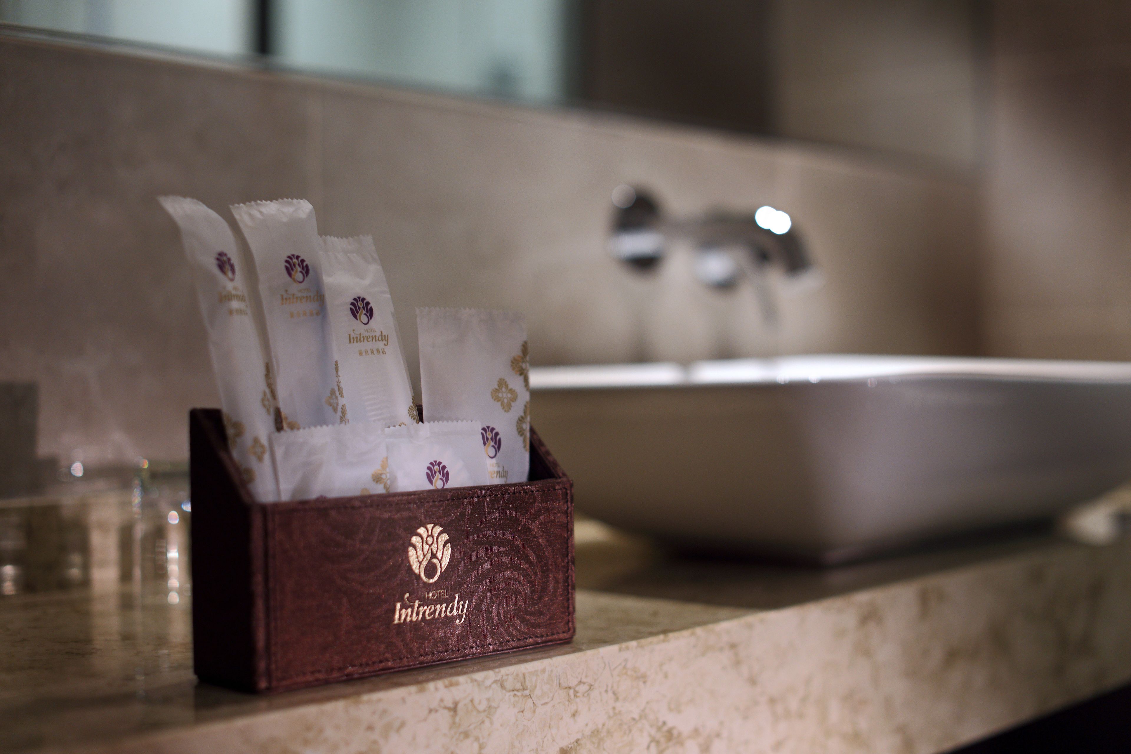 A bathroom with a marble countertop, a sink, and a box containing toiletries.
