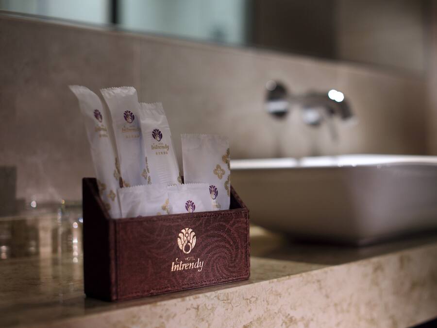 A bathroom with a marble countertop, a sink, and a box containing toiletries.