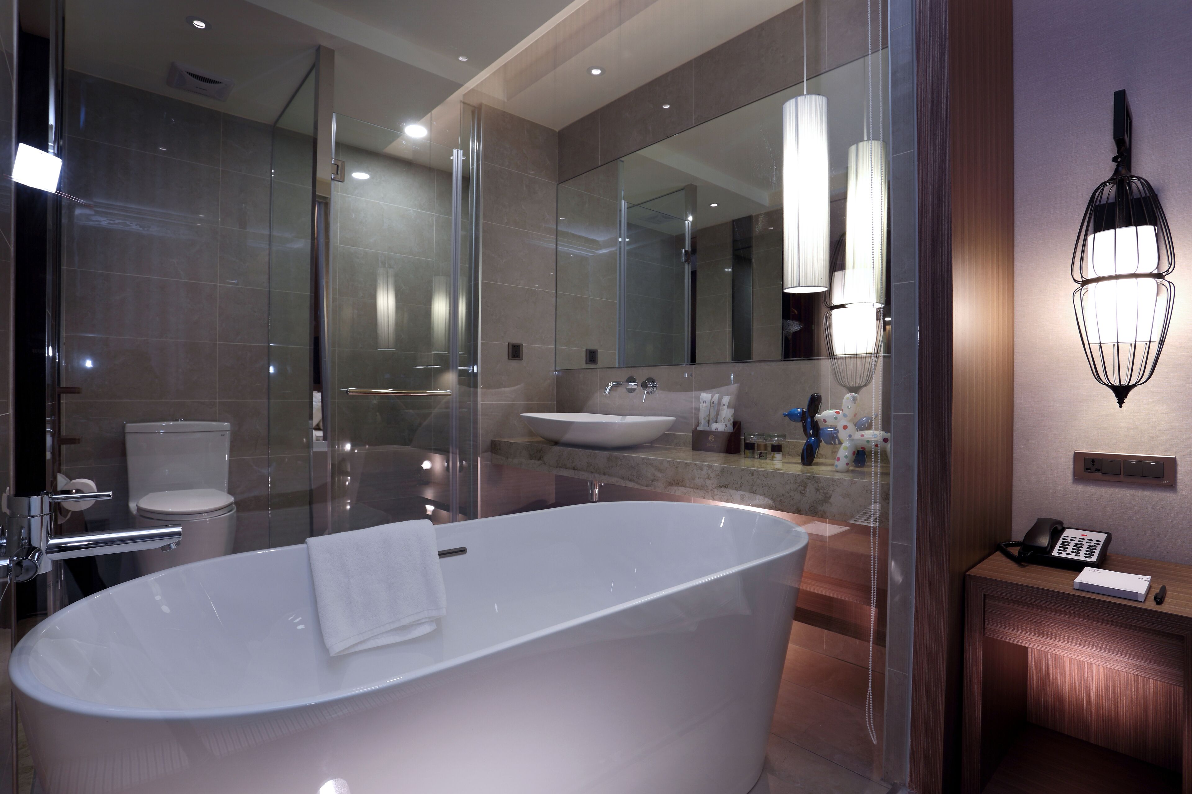 A modern bathroom with a freestanding bathtub, a glass-enclosed shower, and a large mirror.