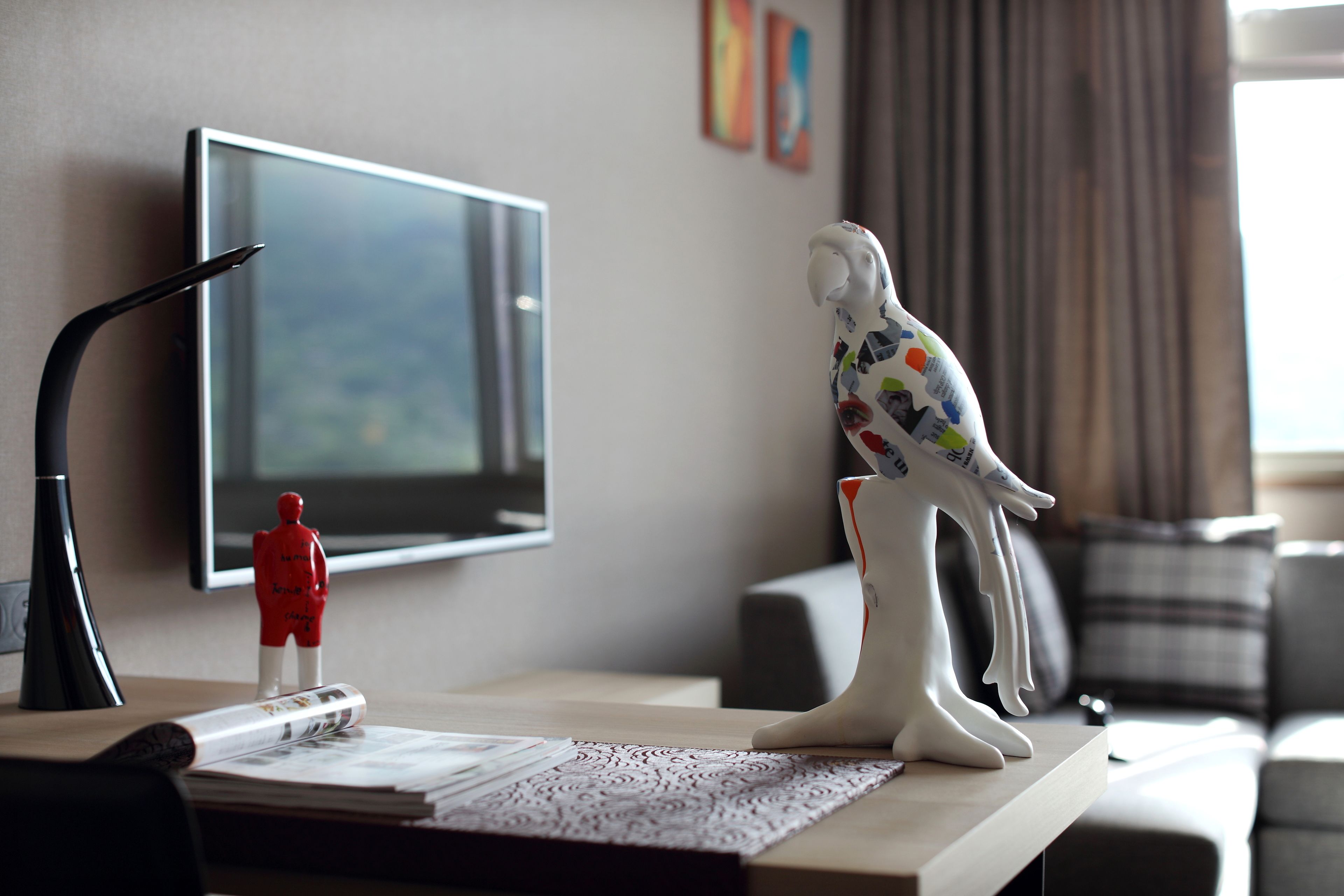 Uma mesa com uma televisão, uma estatueta e um objeto decorativo.